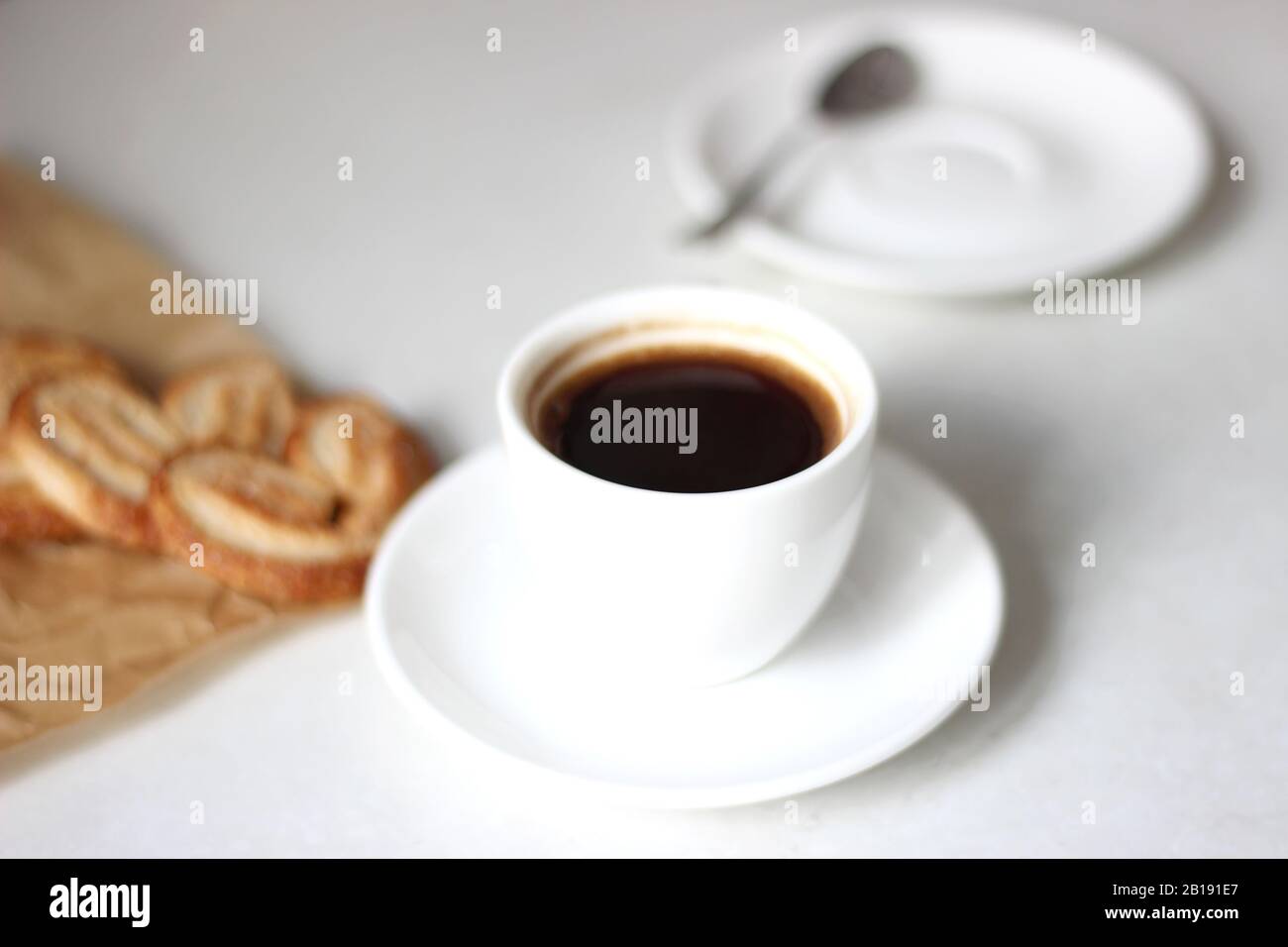 Morgenkaffee. Tasse schwarzen Kaffee mit Palmiers Plätzchen Dessert. Stockfoto