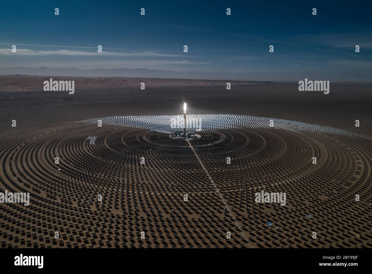 Die Luftaufnahme einer solarthermischen Anlage nutzt Spiegel, die die Sonnenstrahlen auf einem Sammlungsturm fokussieren, um erneuerbare und umweltfreie Energie zu erzeugen. Stockfoto