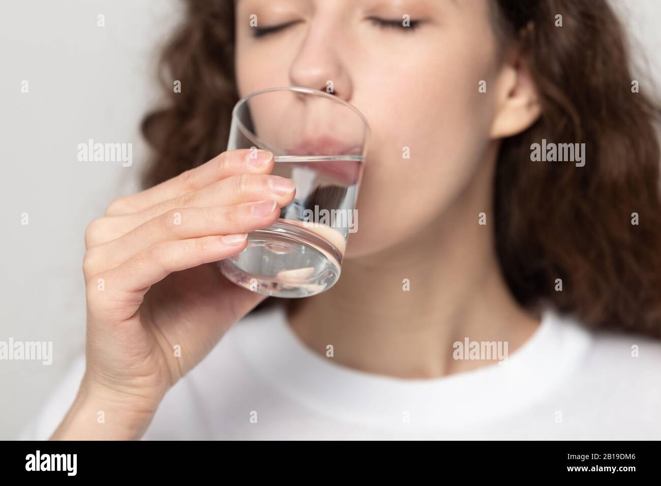 Junge gesunde Frau trinkt Glas frisches, reinem gefiltertes Wasser. Stockfoto