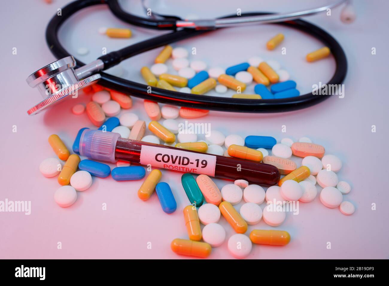 Blut-Reagenzglas für das neue, sich schnell ausbreitende Coronavirus, das seinen Ursprung in Wuhan, China, auf einem großen Haufen verschiedener Pillen hat Stockfoto