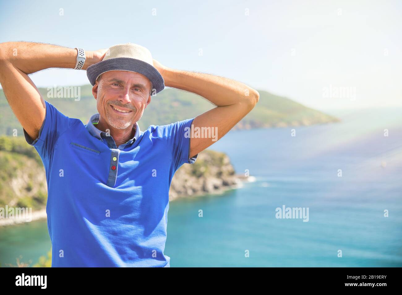 Mann mit Strohhut entspannend am Meer, Meer im Hintergrund. Stockfoto
