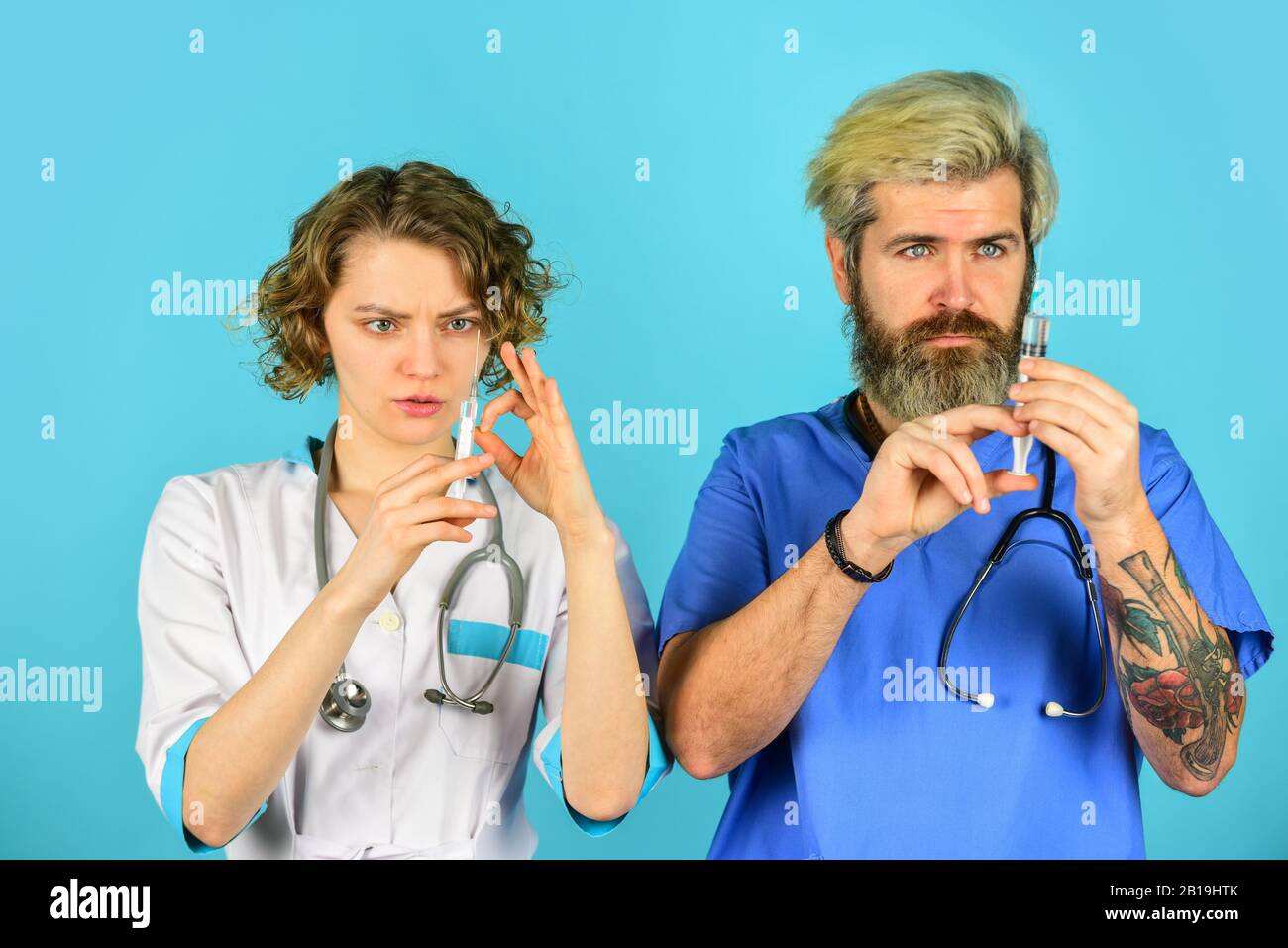 Erfolgreiches Team von Ärzten. Menschen in Uniformen blauer Hintergrund. Medizinisches Personal. Vertrauen Sie unseren Mitarbeitern. Gesundheitswesen. Teamarbeit und Personalkonzept. Arzt und Krankenschwester verwenden Spritze. Stockfoto