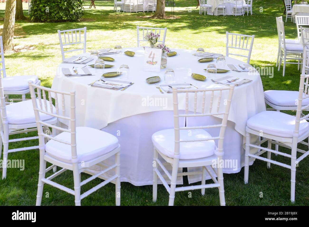 Stühle und Tisch mit weißer Tischdecke für die Feier eines Banketts im Freien. Stockfoto