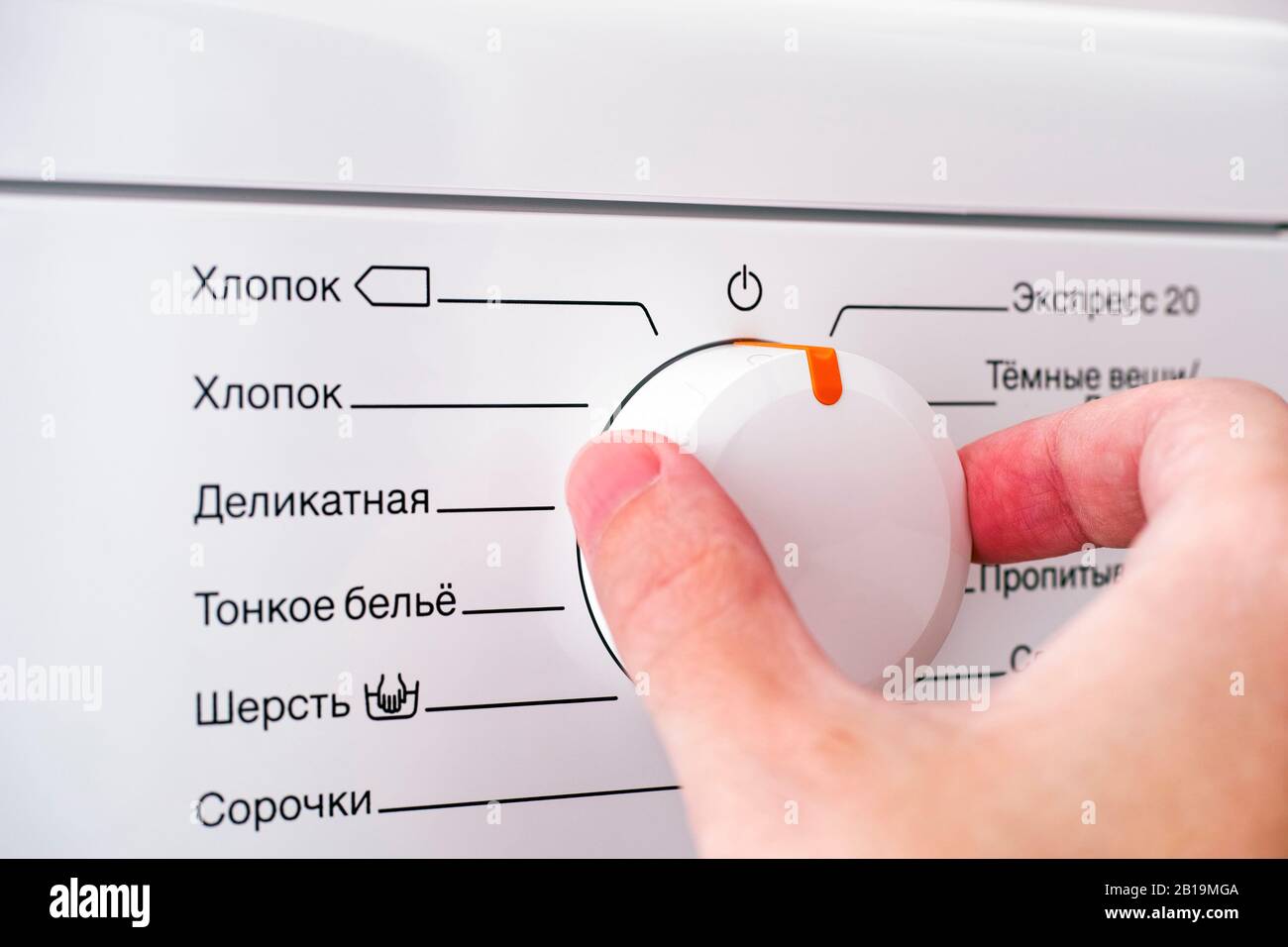 Die Person wählt das Programm für den Waschgang an der Waschmaschine aus. Nahaufnahme. Stockfoto
