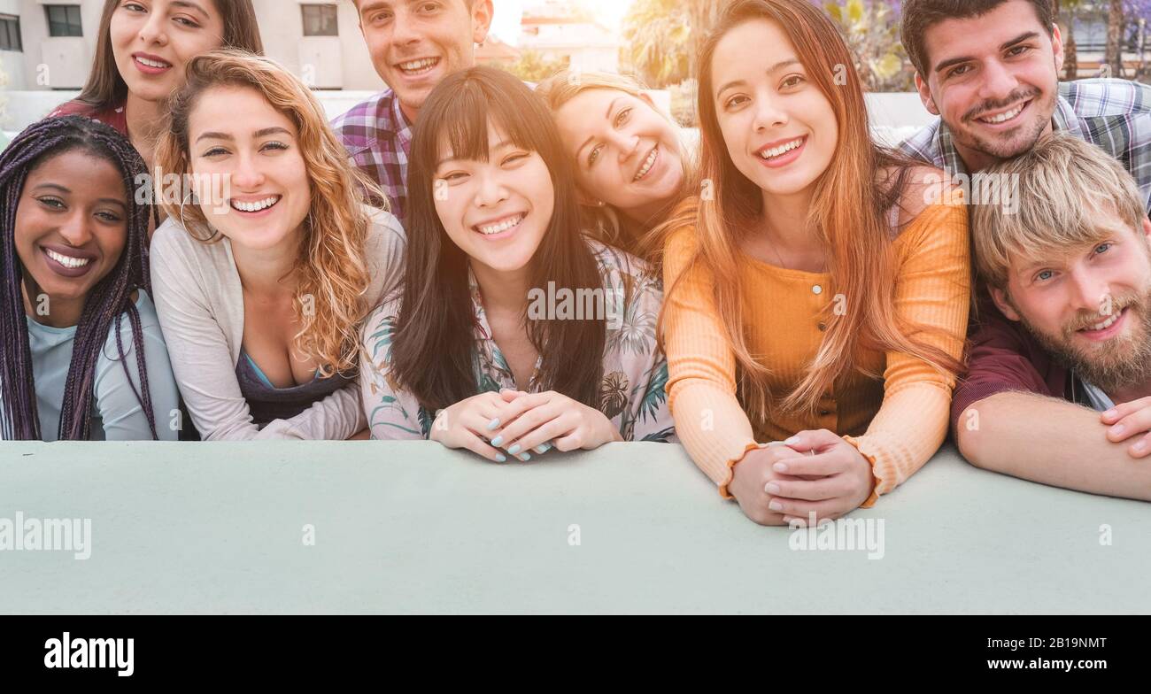 Fröhliche tausendjährige Freunde aus verschiedenen Kulturen und Rassen, die Spaß haben, sich vor der Smartphone-Kamera zu posieren - Jugend- und Freundschaftskonzept - Junges Multir Stockfoto