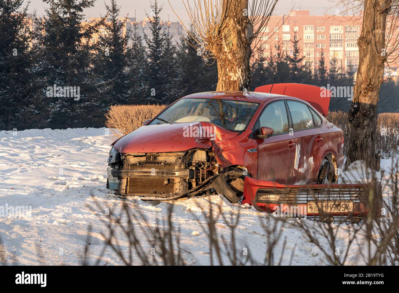 Krasnojarsk, Russland, 3. Februar 2020: Frontalcrash einer roten Volkswagen Polosedan. Im Winter flog das Auto auf einer rutschigen Straße auf die Seite des RO Stockfoto