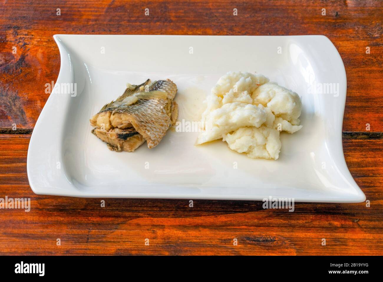 Maismehl-Haferbrei mit gebackenem Fisch - köstliches afrikanisches Mittagessen, Mosambik Stockfoto