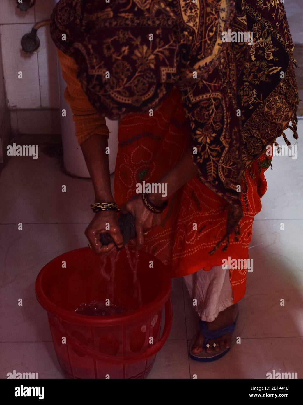 Eine indische Magd drückte ihren Handschlag, bevor sie den Boden säuberte Stockfoto