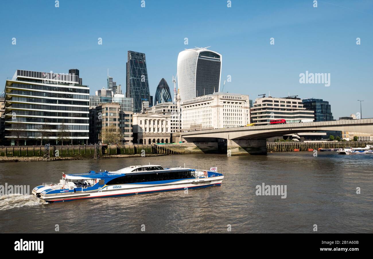 London River Bus. Eine MBNA Thames Clipper an der Themse mit London Bridge und den dahinter liegenden finanziellen Wolkenkratzern der City of London. Stockfoto