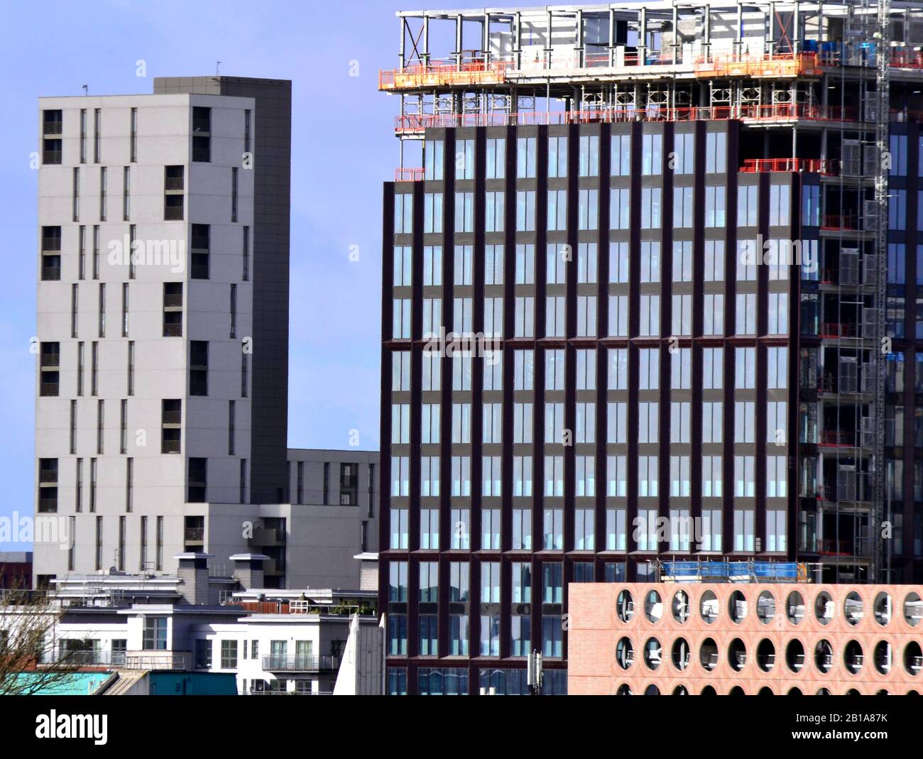 Hochhäuser, darunter eines im Bau, im Zentrum von Manchester, Großbritannien, gegen einen blauen Himmel. Stockfoto