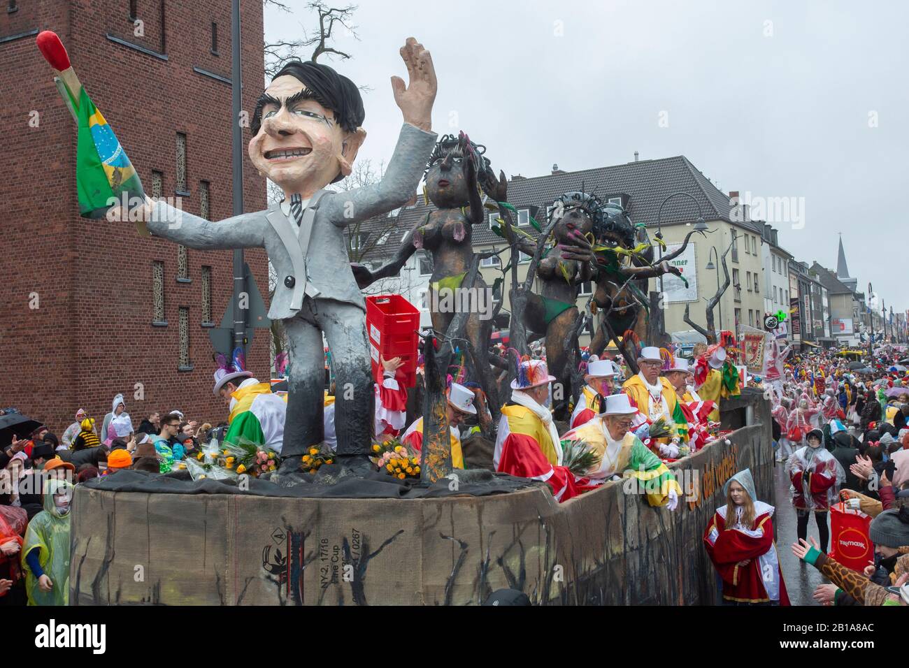 Karneval in Köln: Eine Kutsche zeigt den brasilianischen präsidenten Jair Bolsonaro, mit verbranntem Regenwald und verkohlten Samba-Tänzern zurückgelassen Stockfoto