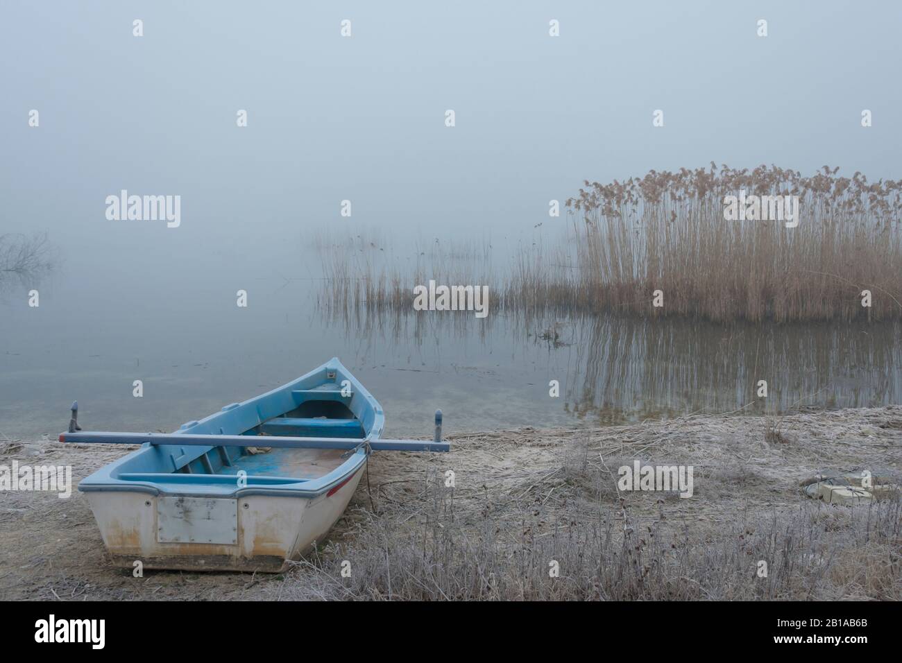 Ein blaues Boot auf einem nebligen See, Vegoritida in Arnissa in Mazedonien in Griechenland Stockfoto