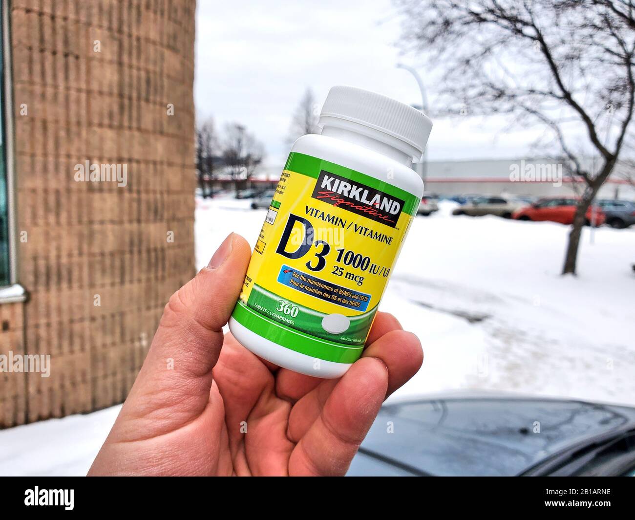 Montreal, Kanada - 10. Februar 2020: Eine Hand, die Kirkland Vitamin D über Costco Lagerhintergrund hält. Vitamin-D-Mangel kann zu einem Verlust führen Stockfoto