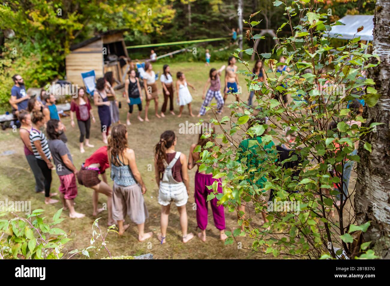 Ein hochwinkeliger selektiver Blick auf eine vielfältige Gruppe von Menschen, die während eines multikulturellen Erdfestes mit Kopierraum im Kreis auf einem Waldcamping stehen Stockfoto