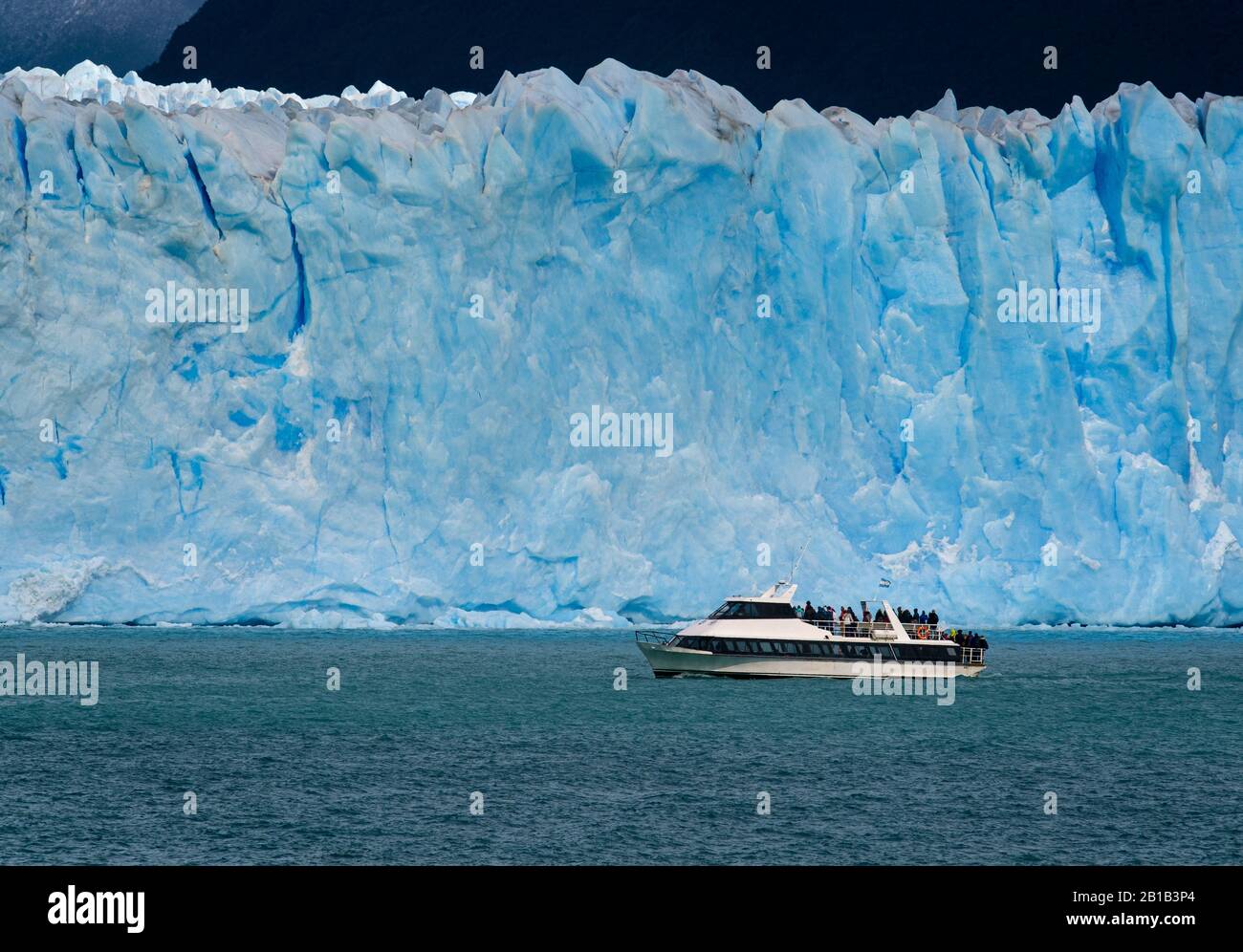 Nationalpark LOS GLACIARES, ARGENTINIEN - CIRCA FEBRUAR 2019: Boot mit Touristen, die durch das Wasser des Argentino Lake auf dem Gletscher Perito Moreno, a Stockfoto