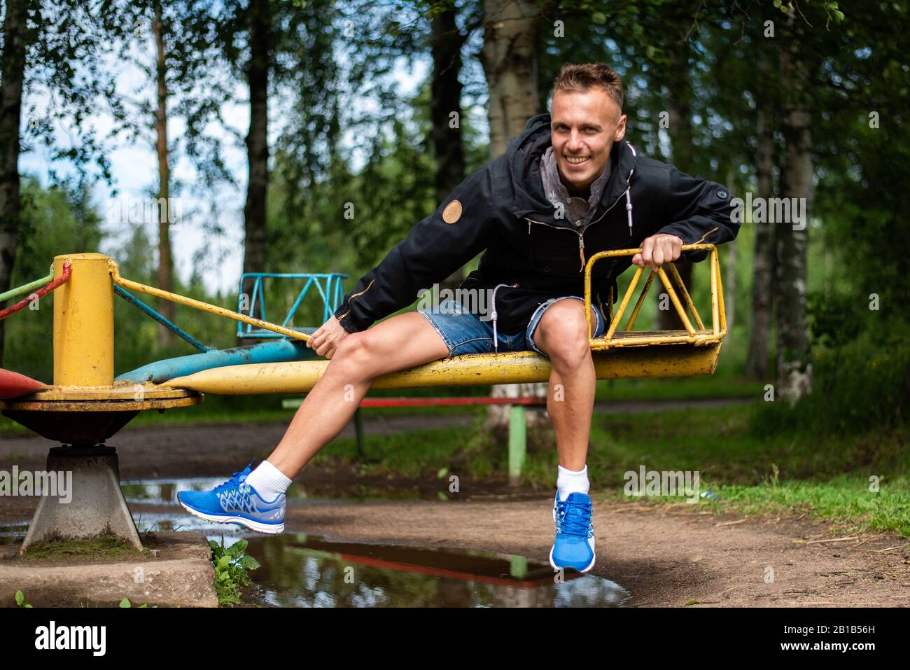 Ein Mann auf Babyschaukeln und Karussells. Stockfoto