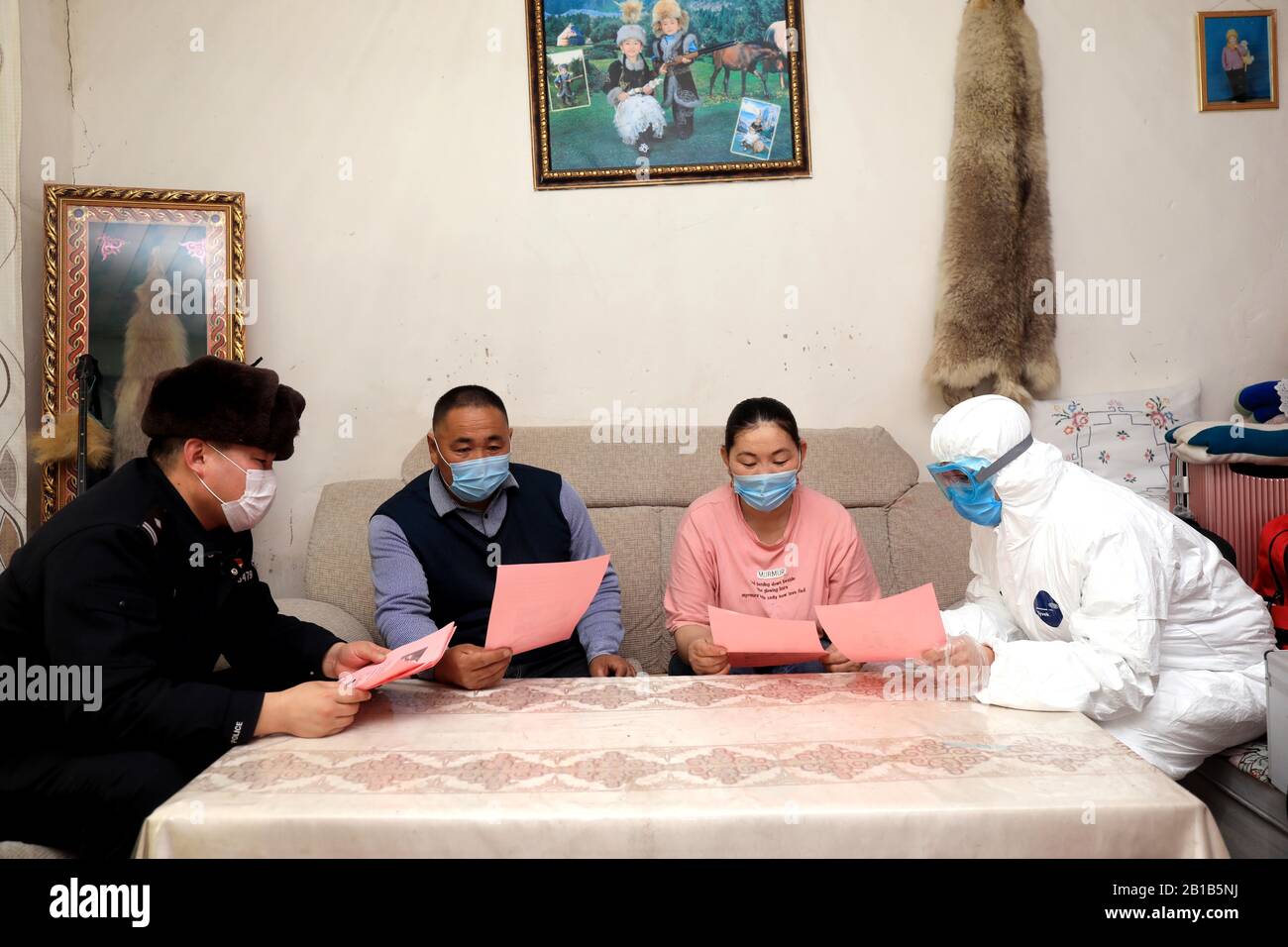 Der chinesische Polizist und medizinische Facharbeiter veröffentlichte am 19. Februar 2020 Informationen über die Prävention des neuen Coronavirus und der Pneumonie einer örtlichen Familie im Landkreis Fuyun, Präfektur Altay, im Nordwesten Chinas Xinjiang Uygur. (Foto von RAN / Costfoto / Sipa USA) Stockfoto