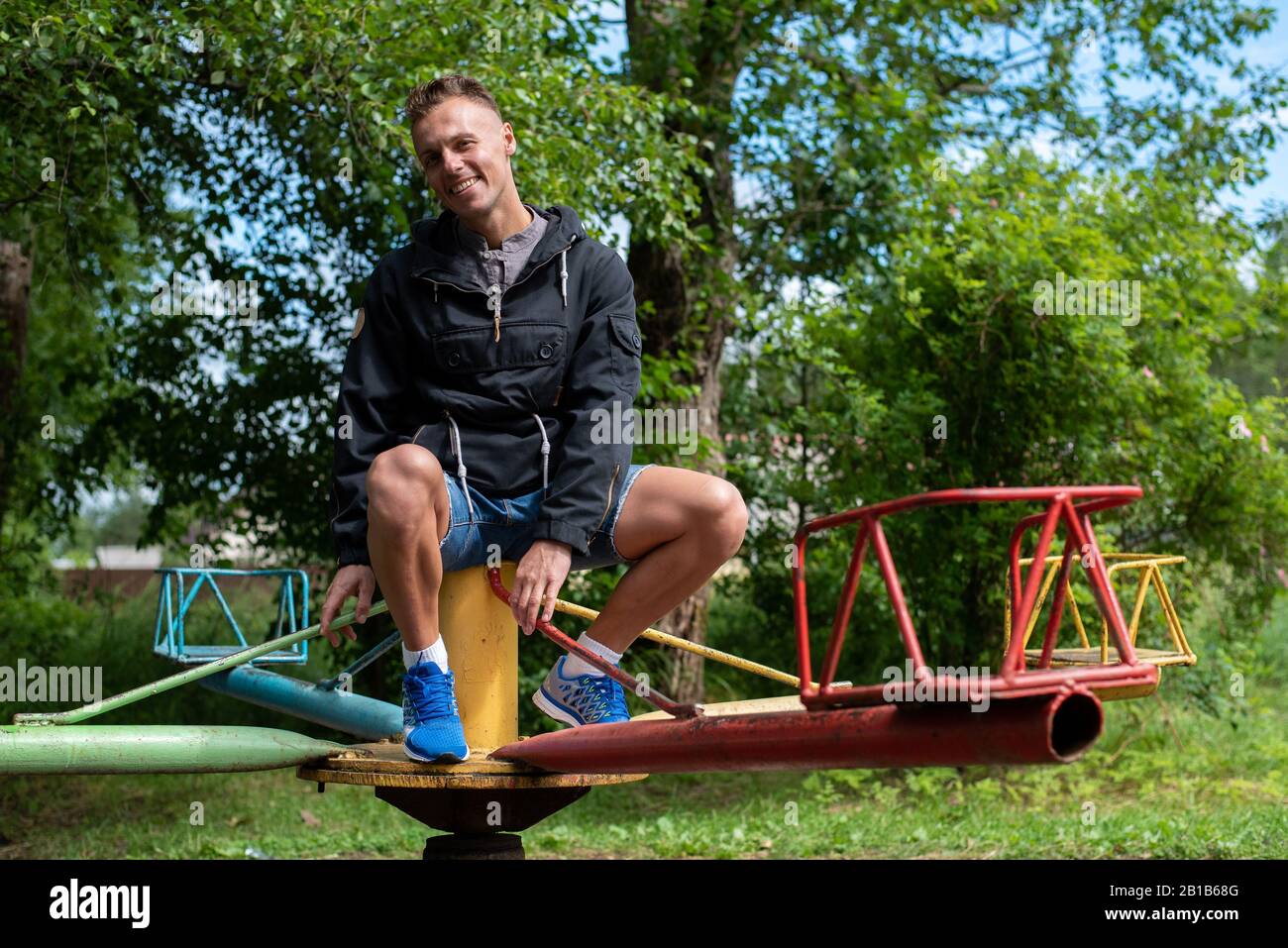 Ein Mann auf Babyschaukeln und Karussells. Stockfoto