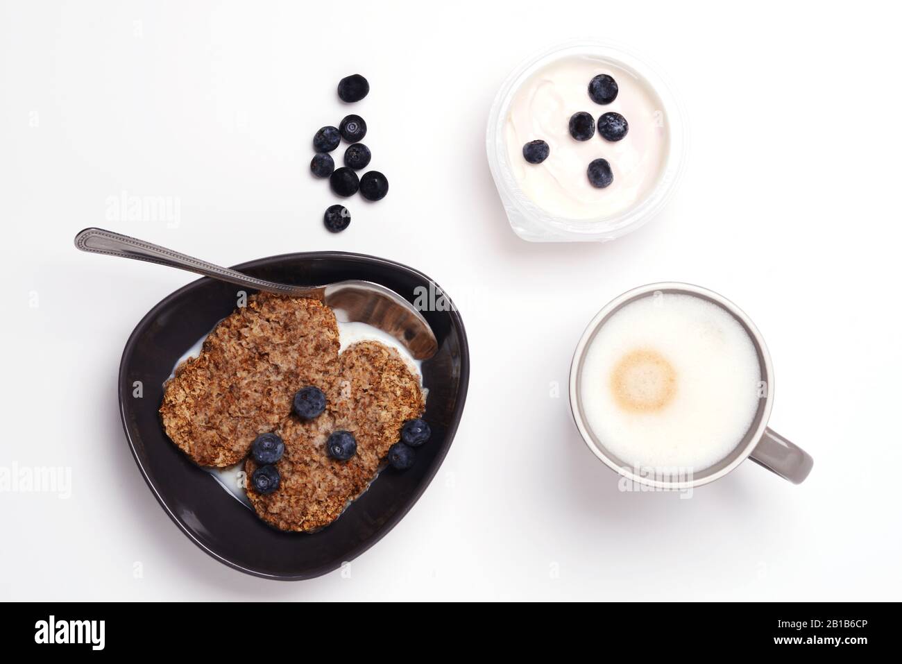 Müsli und Cornflakes mit Joghurt und Kaffee in Weiß Stockfoto