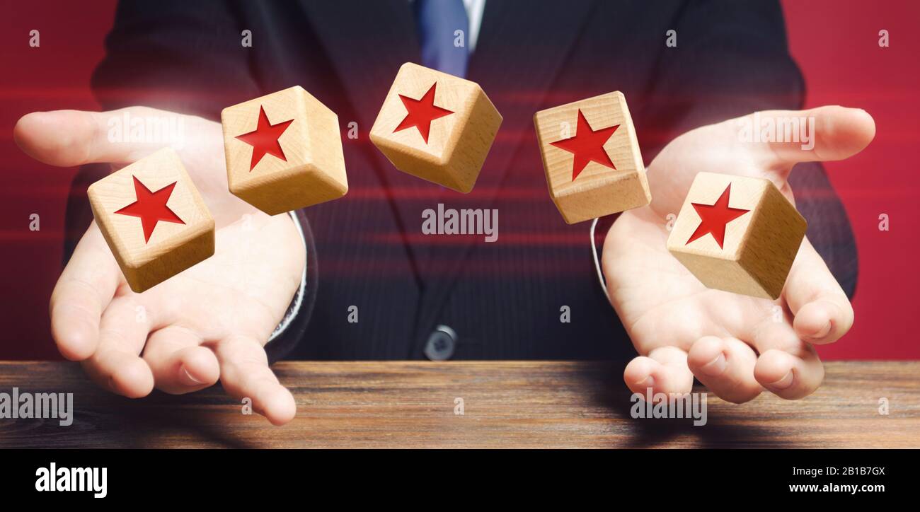 Würfel, die von einem Mann geworfen werden, machen fünf Sterne. Bewertung von Hotels und Restaurants. Verleihung des höchsten Ranges. Hochwertige Qualität, guter Service. Feedback-Rate. Stockfoto