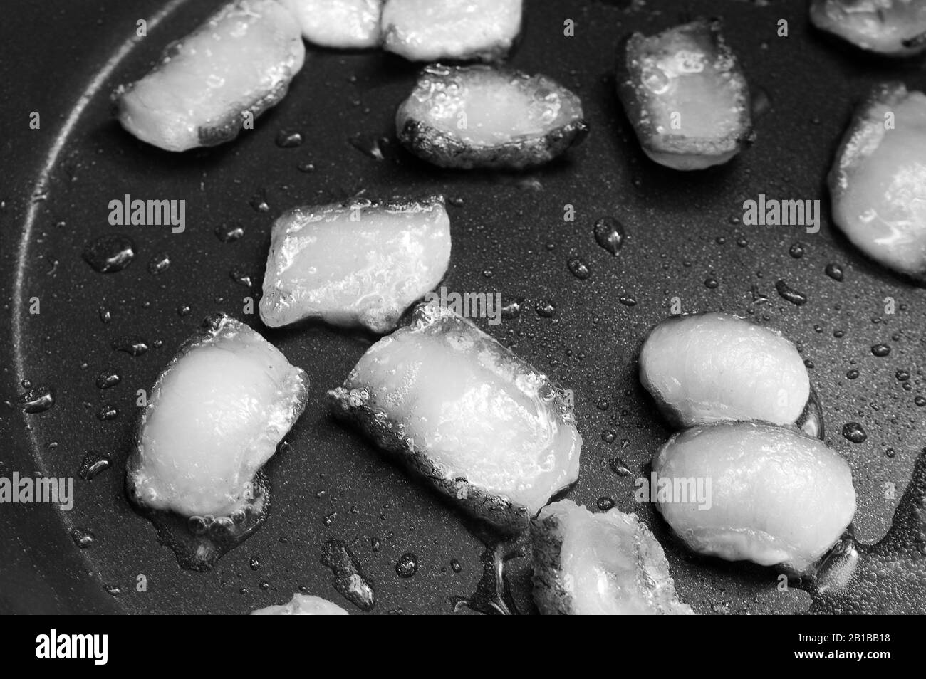 Speckscheiben in eigenem Fett auf Frittierfett braten. Nahansicht. Schwarz-weiß gezungtes Bild. Selektiver Fokus. Stockfoto