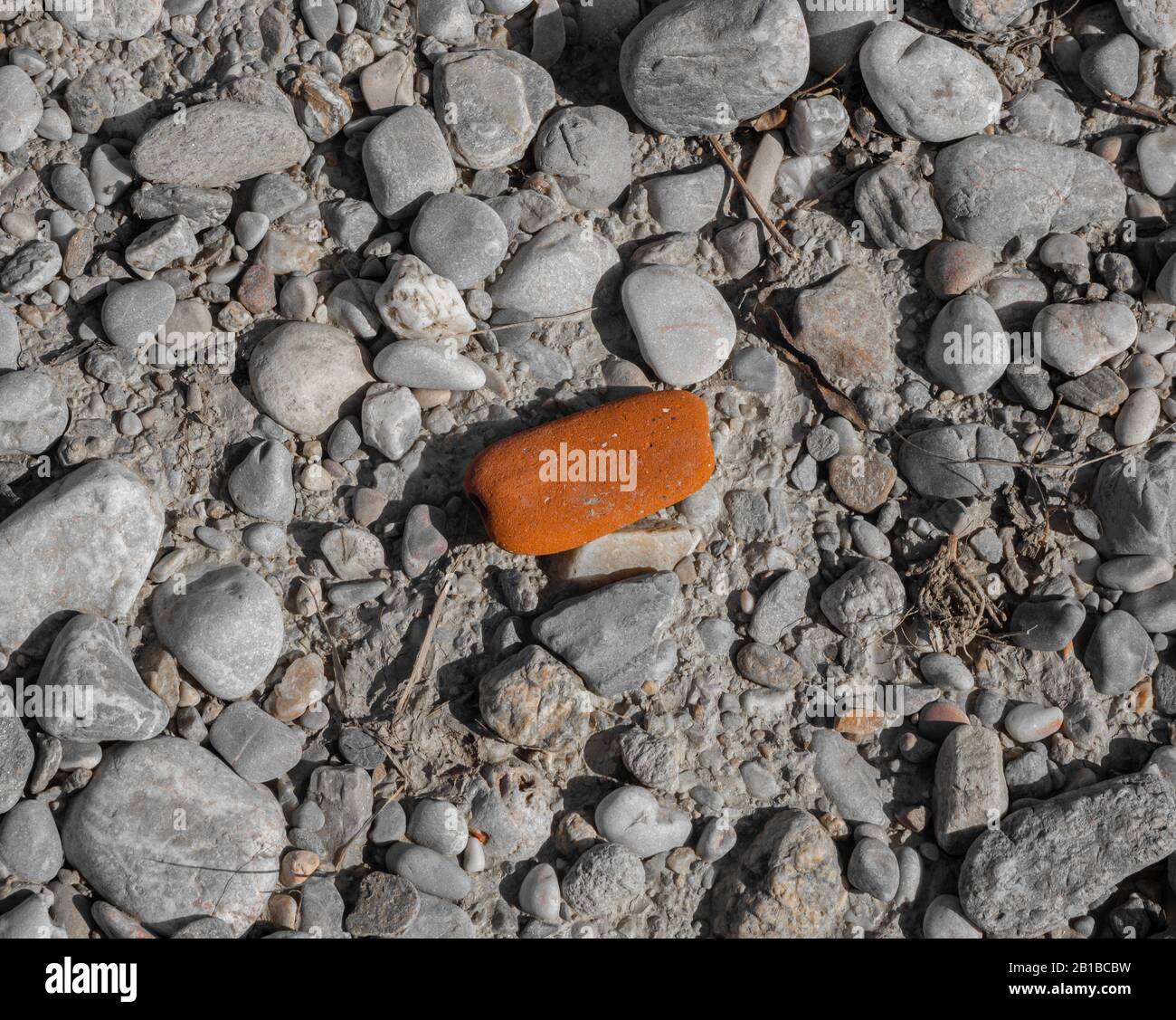 Ein roter Stein auf steinigem Boden Stockfoto