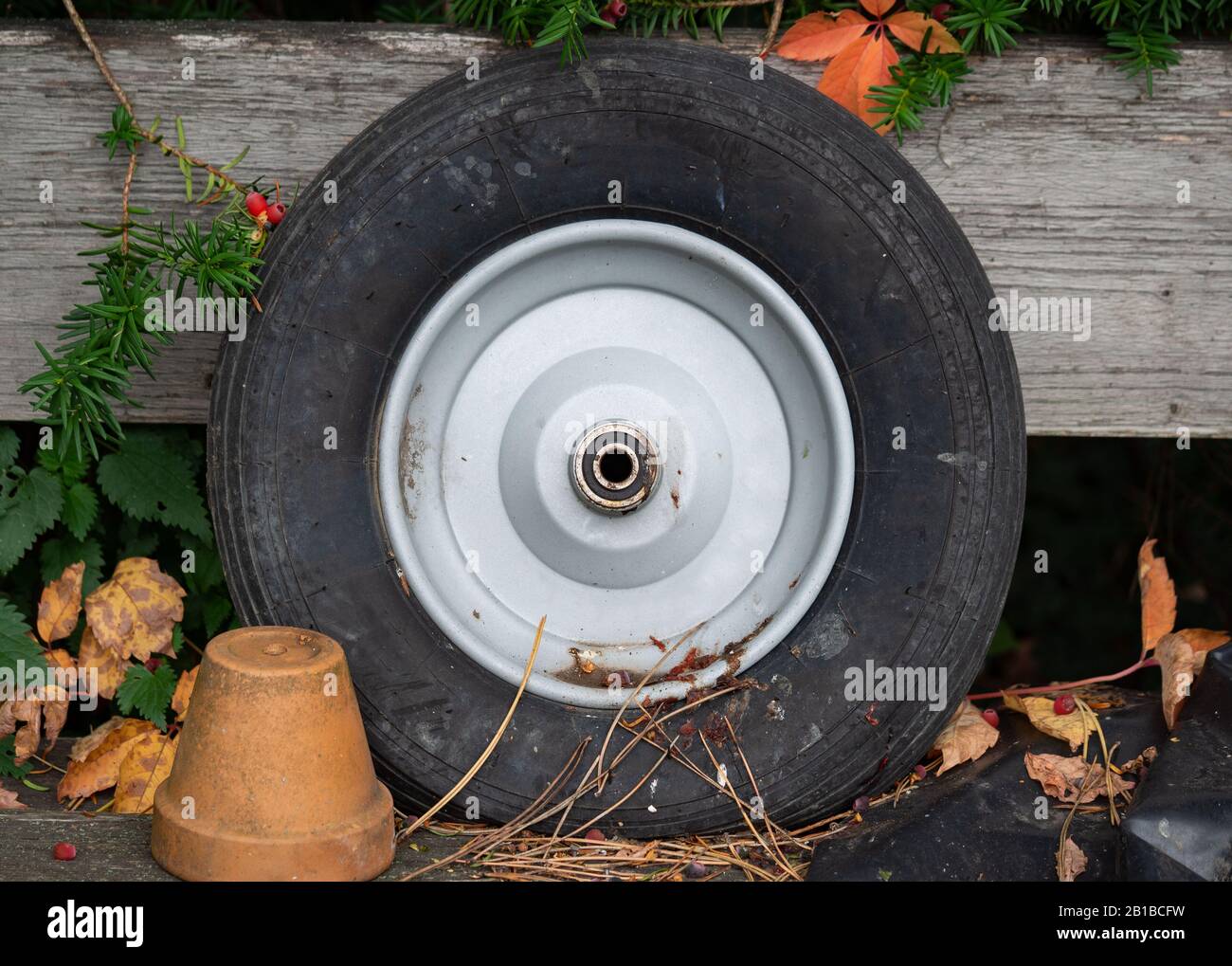 Alter Reifen auf Holz und einem Tontopf Stockfoto