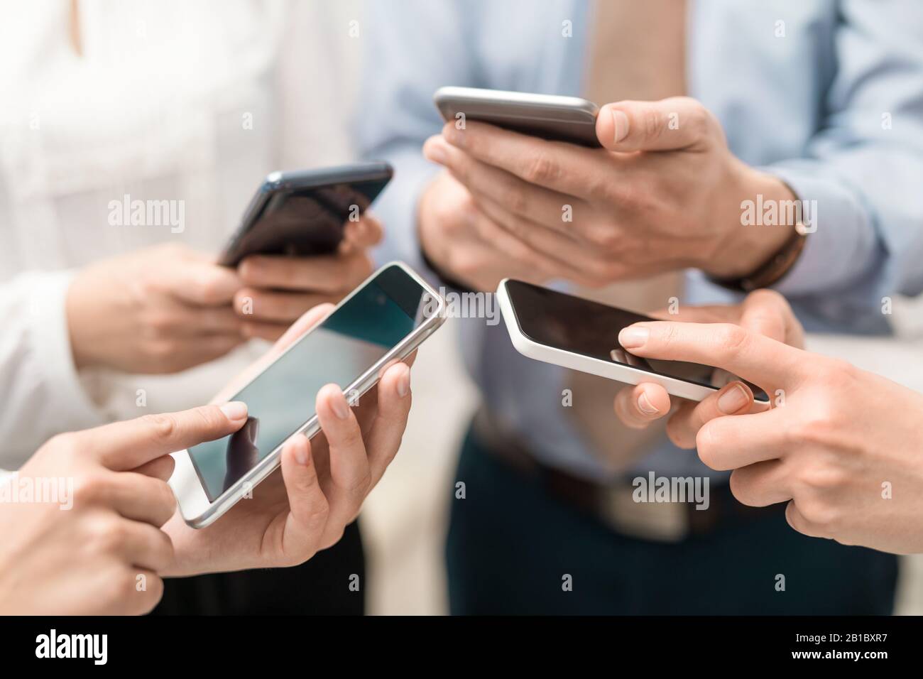 Gruppe junger Hipster, die das Telefon in den Händen halten. Freunde, die Spaß mit Smartphones haben. Stockfoto