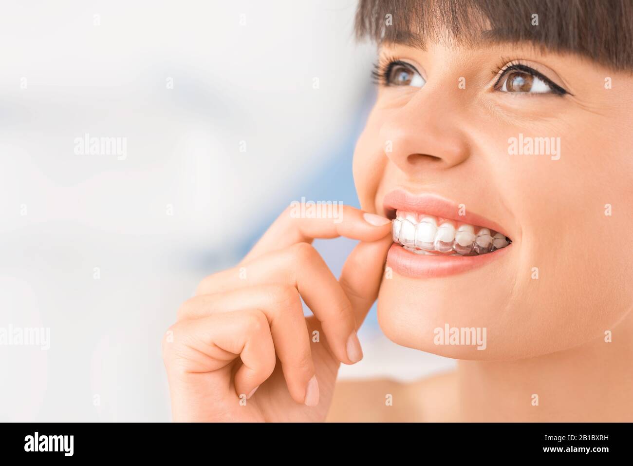 Frau mit kieferorthopädischen Silikon Trainer. Unsichtbare Zahnspangen Ausrichter. Mobile kieferorthopädische Gerät für zahnmedizinische Korrektur. Stockfoto