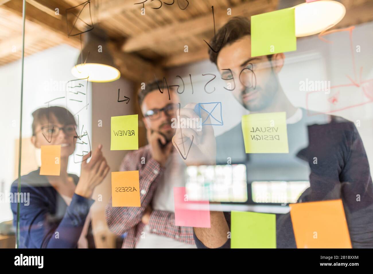 Business Leute, die im Büro und Post-it Notizen Idee zu teilen. Brainstorming Konzept. Haftnotiz auf einer Glaswand. Stockfoto