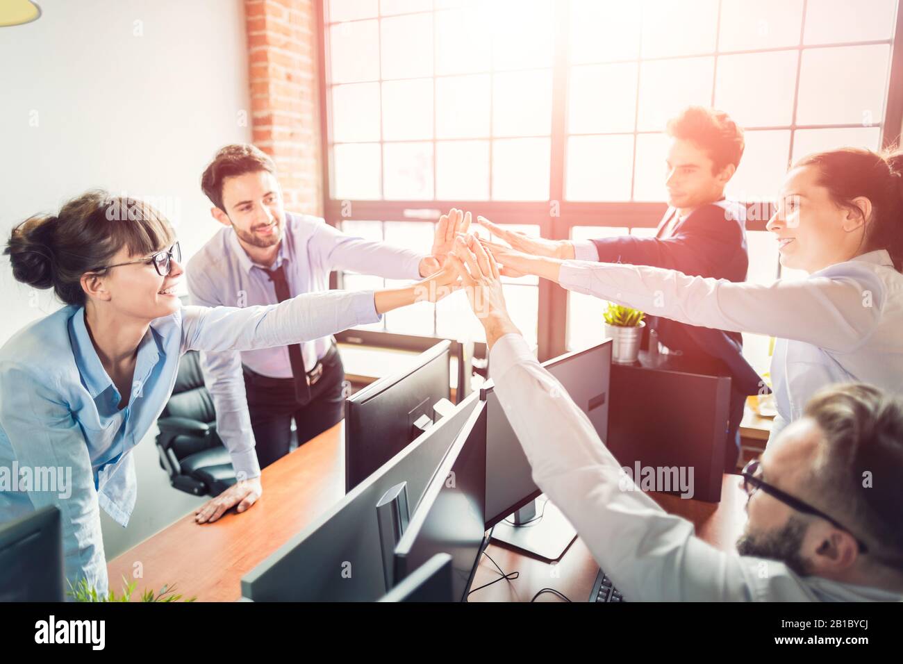 Geschäftsleute zeigen gerne Teamarbeit und geben fünf im Büro. Teamwork-Konzepte. Stockfoto