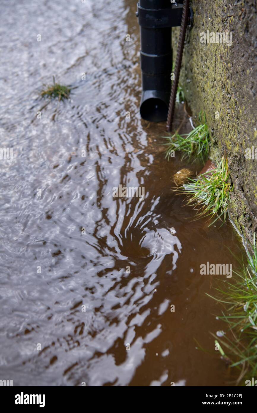 Schmutzwasser von einem Hof, der nach einem Sturm einen Abfluss abführt. North Yorkshire, Großbritannien. Stockfoto