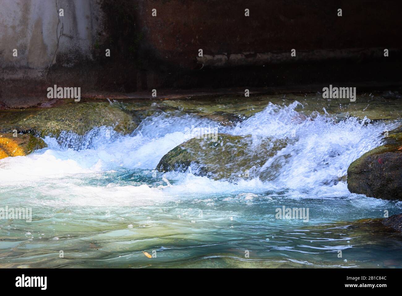 Wasserfluss zwischen Steinen, landschaftlich schöner Blick auf fließendes Wasser zwischen Steinen Stockfoto