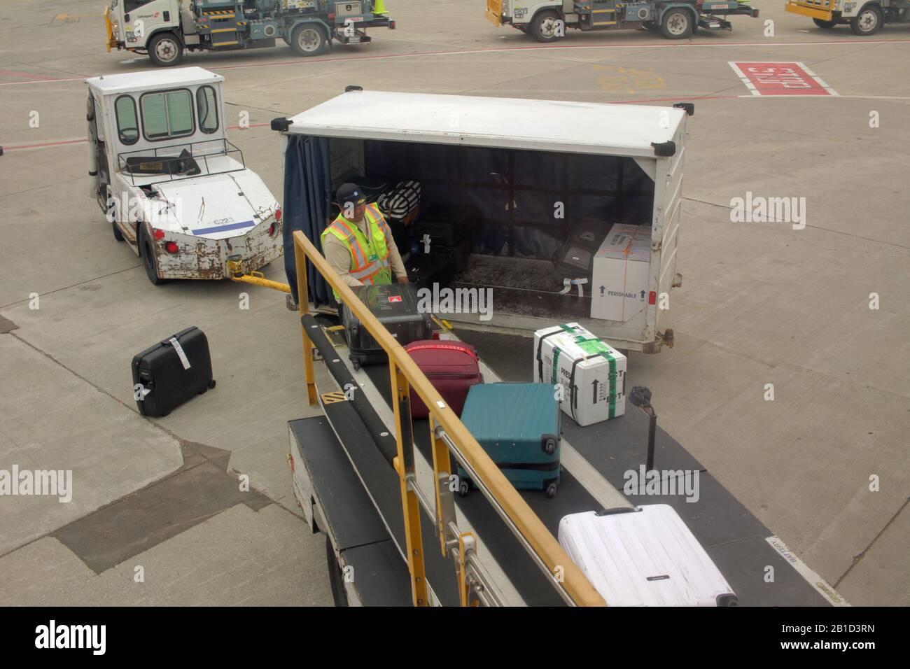 Gepäckhandler am Flughafen Chicago O'Hare, USA, entladen Taschen von einem Flugzeug Stockfoto