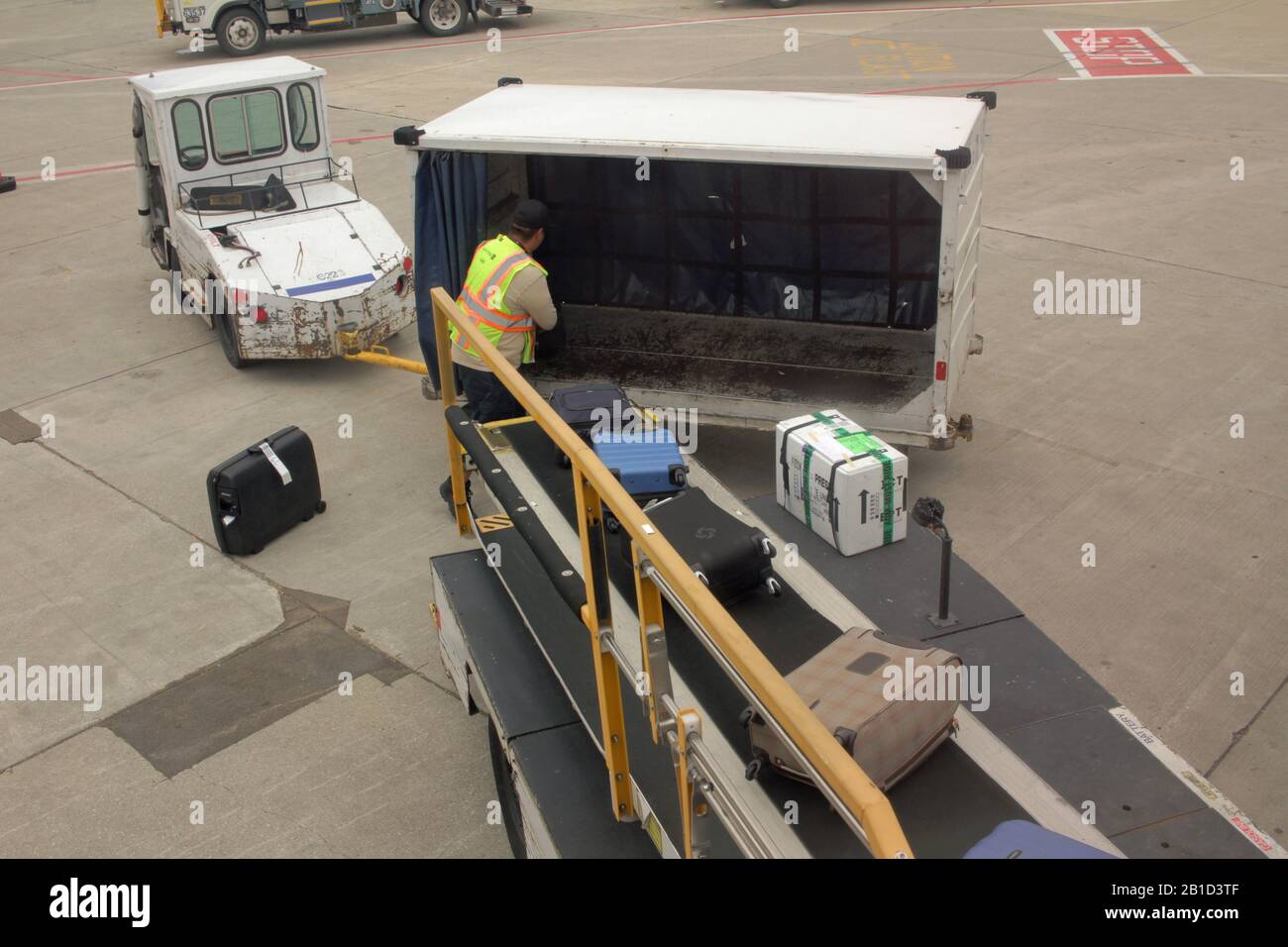 Gepäckhandler am Flughafen Chicago O'Hare, USA, entladen Taschen von einem Flugzeug Stockfoto