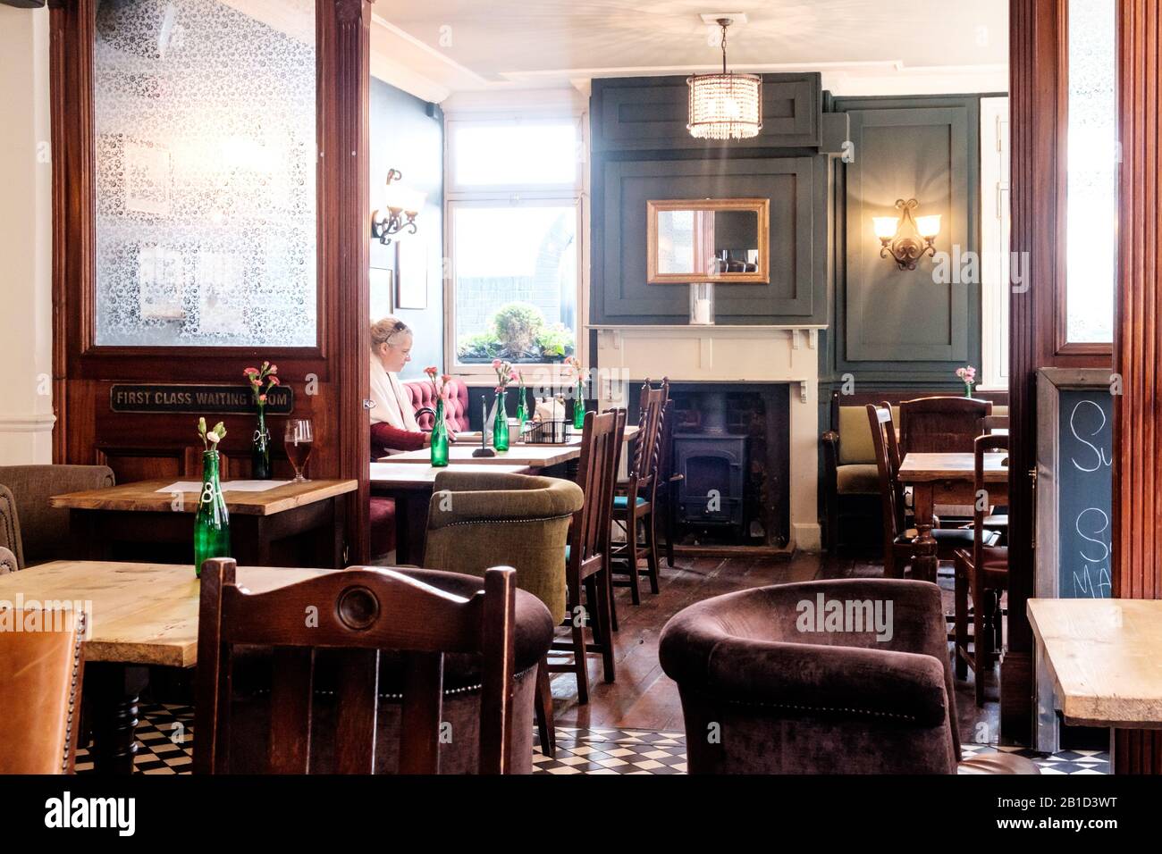 Frau, die am Laptop arbeitet in einem Pub in der Chiswick High Street, London, England Stockfoto