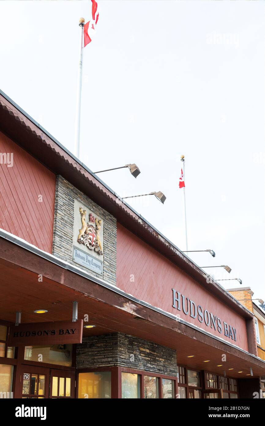 Banff, KANADA - 15. FEBRUAR 2020: Hudson's Bay Shop mit Schild an der belebten Banff Avenue in Alberta, Kanada. Hudson's Bay, auch bekannt als Bay oder HBC, ist Stockfoto