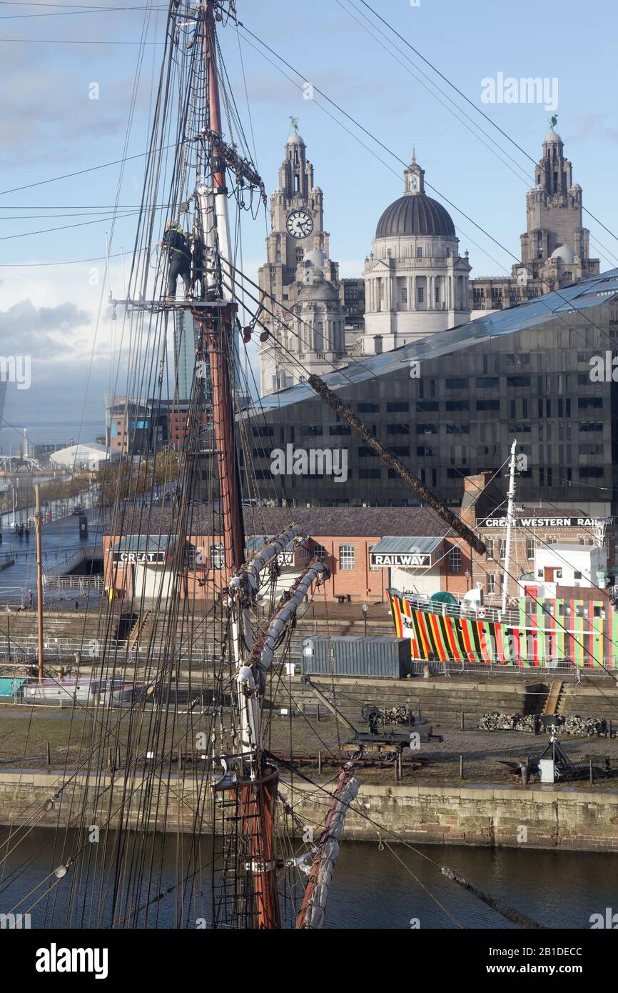 Liverpool Waterfront und die Drei Graces vom Merseyside Maritime Museum aus gesehen; das farbenfrohe Schiff ist der Lotsenschneider Edmund Gardner Stockfoto