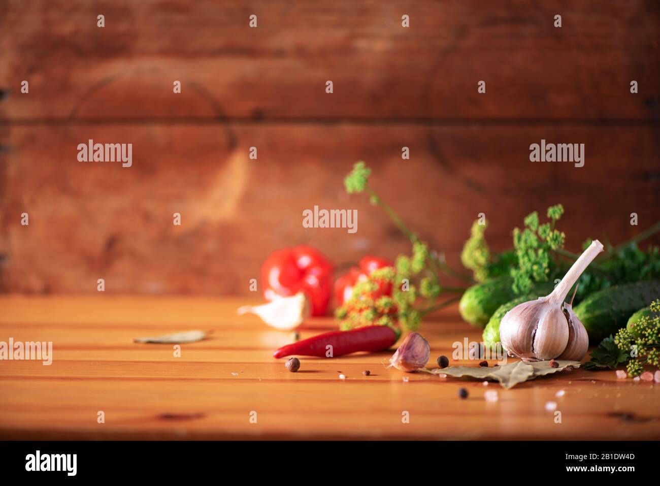 Zutaten, Gewürze und Kräuter zum Konservieren von Gurken über Holzgrund. Kopierbereich. Dill Blumen, Lorbeerblatt, Meerrettichblatt, Knoblauch, Gherkins Stockfoto