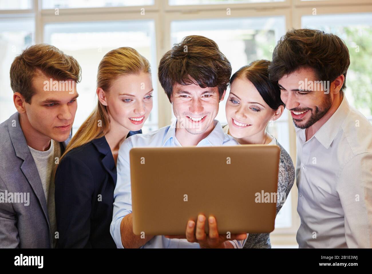 Das junge Business-Team sieht auf dem Monitor von einem Laptop aus zufrieden Stockfoto