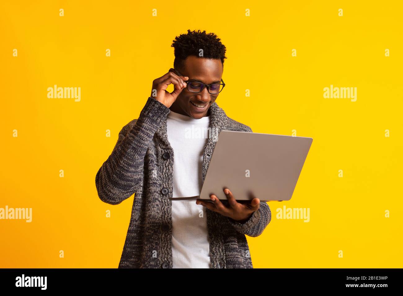afroamerikanischer Mann-Programmierer mit Laptop auf Gelb Stockfoto
