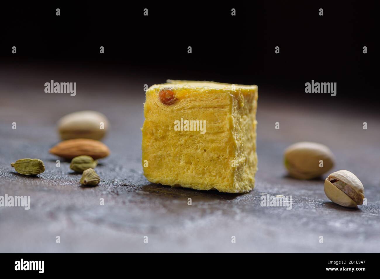 Ein Würfel aus Dessert soan Papdi, Kardamom Körner, Pistazien und Mandel auf Beton Küchenoberfläche. Stockfoto