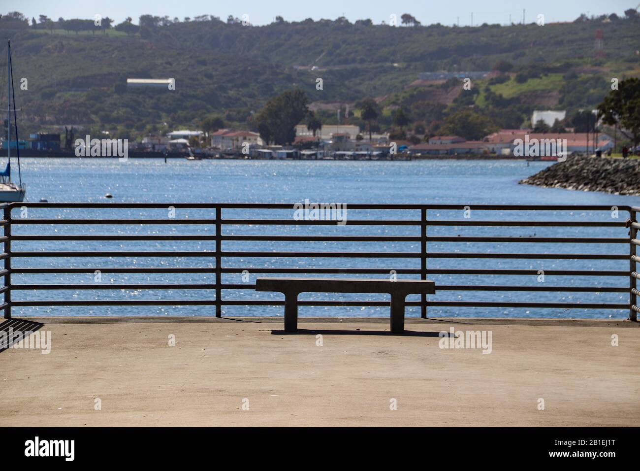 Leere Zementbank am Angelpier mit Blick auf die Segelboote in San Diego Bay Stockfoto