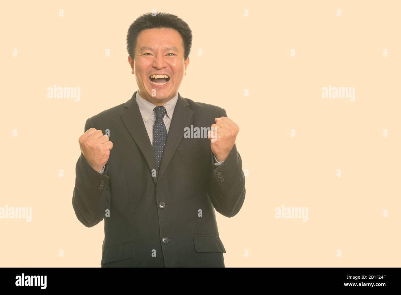 Studio shot von Happy japanischen Geschäftsmann, Lächeln, während sie aufgeregt Stockfoto