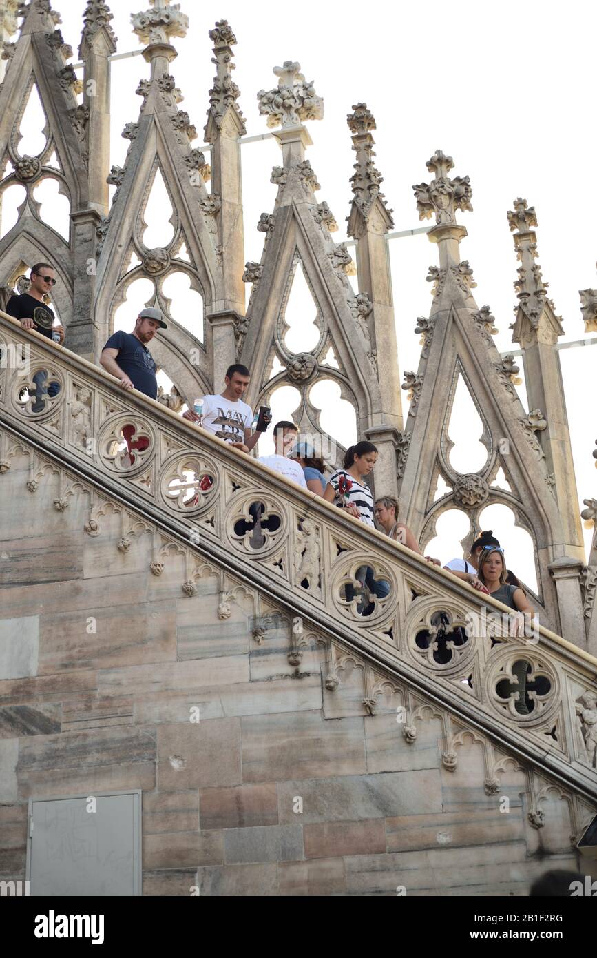 ‎Tourists gehen Sie eine offene Treppe vorbei an italienischen, gotischen Openwork und Pinnacles des Terrazza sul Duomo, Dachterrasse des Mailänder Doms Stockfoto