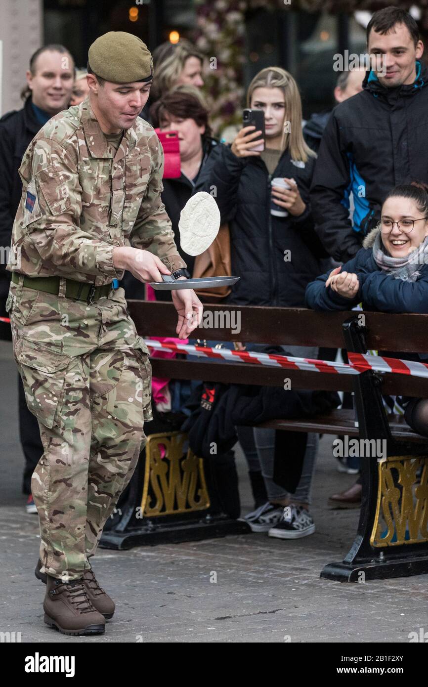 Windsor, Großbritannien. Februar 2020. Ein Soldat der 1st Battalion Welsh Guards zeigt seine Flipping-Fähigkeiten und seine ausgefallene Fußarbeit, als er am Dienstag in Shrove in der Windsor and Eton Flippin' Pancake Challenge um die Unterstützung des Alexander Devine Children's Hospice Service konkurriert. Credit: Mark Kerrison/Alamy Live News Stockfoto