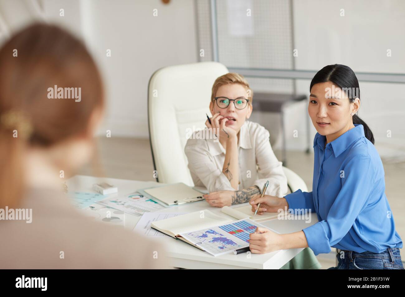 Drei moderne junge Frauen diskutieren Projekt in einer Geschäftsbesprechung Stockfoto