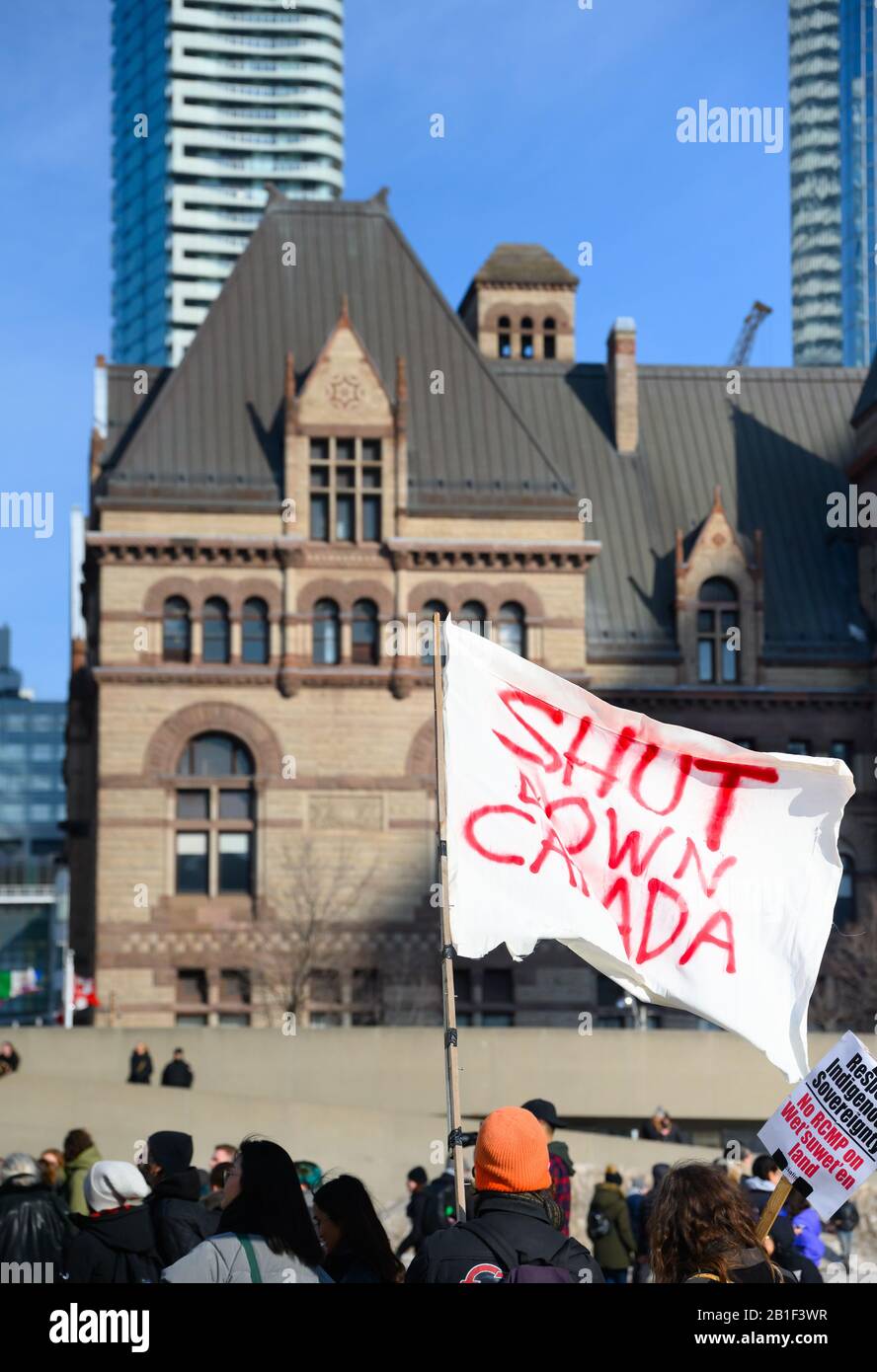 Ein Anti-Pipeline-Protestler wellt eine Stillgelegte Flagge Kanadas auf dem Nathan Phillips Square, nachdem er aus Solidarität mit dem Wet'suwet'en protestiert hat. Stockfoto