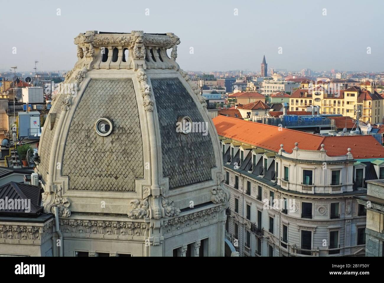 Ein enger Blick auf die Balustrade überragte die Dachkuppel des Palazzo Meroni - Löwen und Blumengarlands, Okulifenster und die Stadt Mailand im Hintergrund Stockfoto