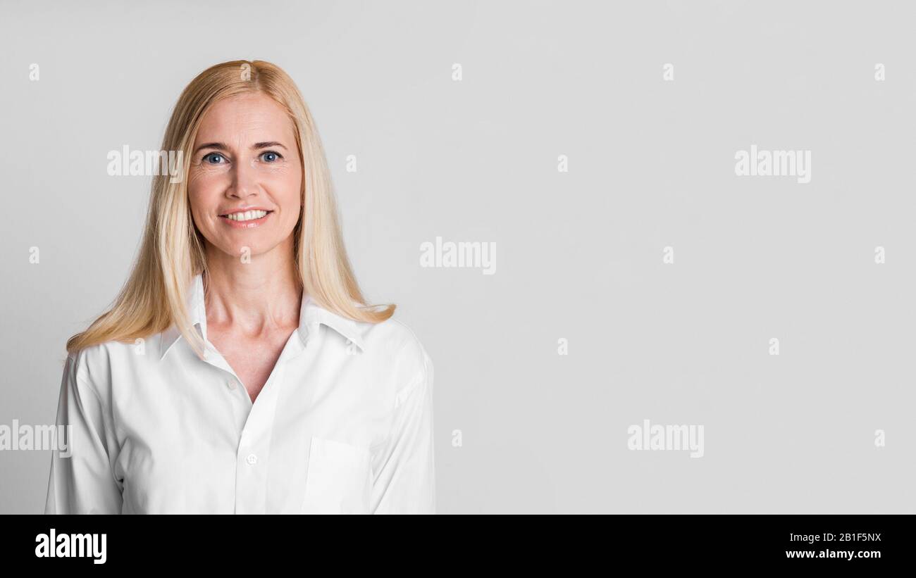 Lächelnde Frau mittleren Alters mit Blick auf die Kamera im Studio Stockfoto
